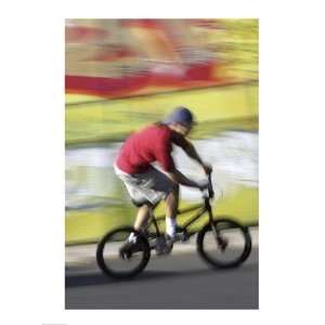 Side profile of a teenage boy performing a stunt on a bicycle Poster 