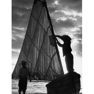  Fisherman Untying the Sail as the Sun Sets over the Water 