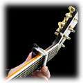 Push the small black lever to release the arms Position the capo 
